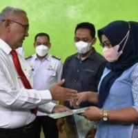 Bupati Kuningan, H. Acep Purnama, SH, MH menyerahkan sertifikat hak atas tanah melalui program Pendaftaran Tanah Sistematis Lengkap (PTSL).